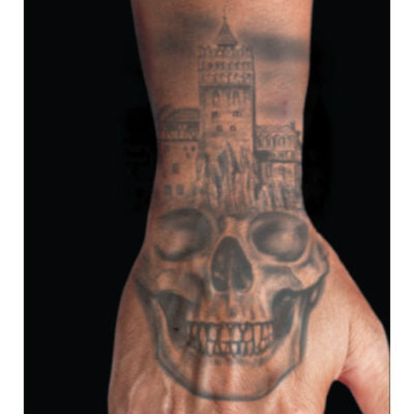 skull hand temporary tattoo with castle in background.
